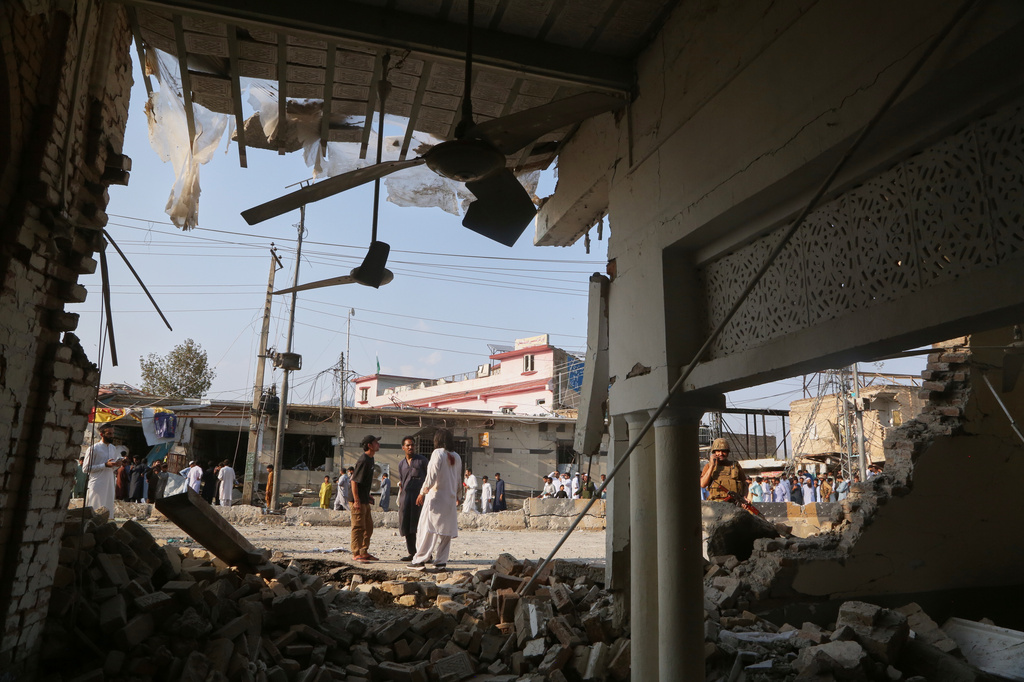 An Army soldier and local residents look at a damaged portion of a mosque after a bomb exploded in Kohat, in northwestern Pakistan, Friday, Sept. 18, 2026. (AP Photo/Muhammad Sajjad)