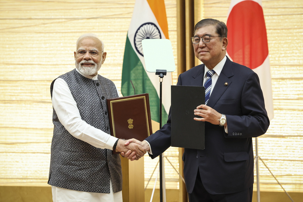 India's Prime Minister Narendra Modi, left, and Japan's Prime Minister Shigeru Ishiba shake hands during a joint press conference in Tokyo, Japan, Aug. 29, 2025. (Takashi Aoyama/Pool Photo via AP)