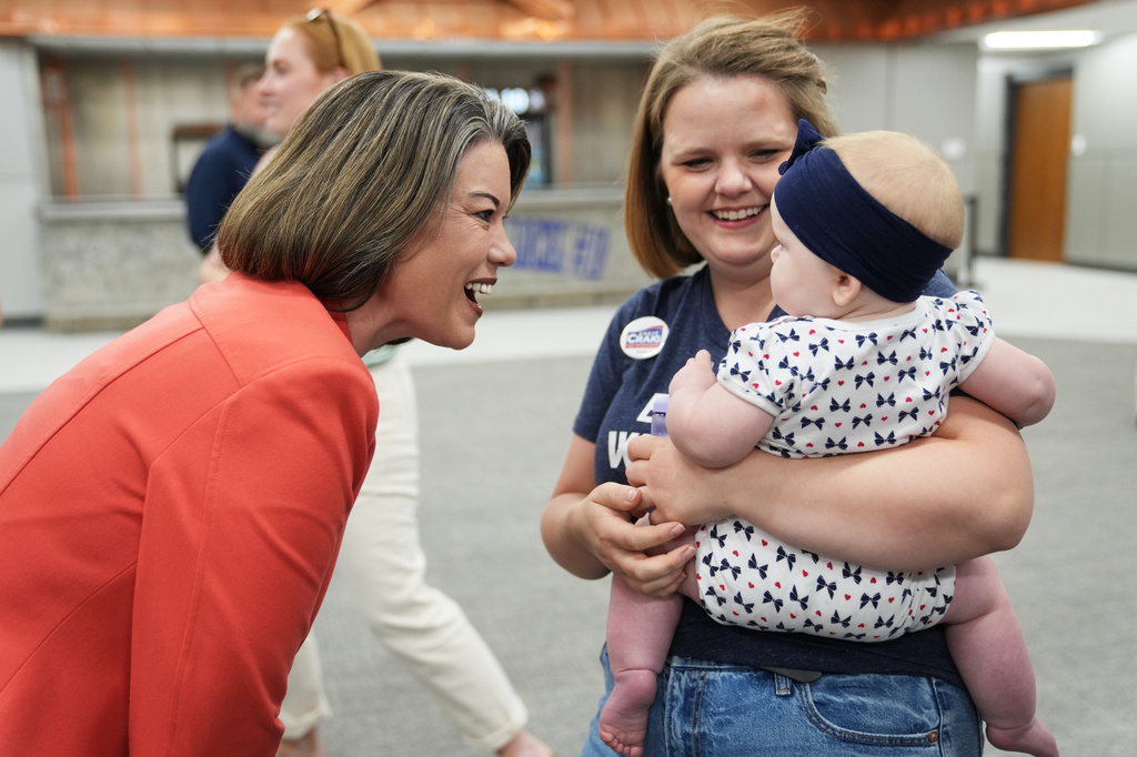 U.S. Rep. Angie Craig, D-Minn., candidate for U.S Senate, greets Merci Wolff and her daughter during a canvassing event at SMART Sheet Metal Workers Local #10 headquarters, Monday, Aug. 10, 2026, in St. Paul, Minn. (AP Photo/Ellen Schmidt)