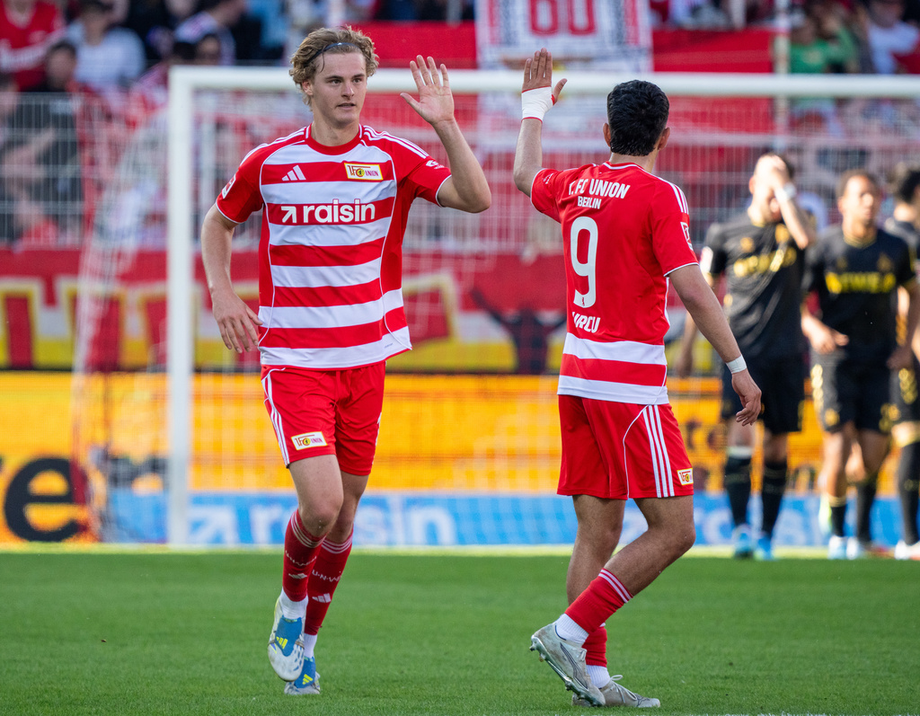 Union Berlin's Tom Rothe, left, celebrates after scoring his side's first goal during the German Bundesliga soccer match between 1. FC Union Berlin and 1. FC Köln. (Soeren Stache/dpa via AP)