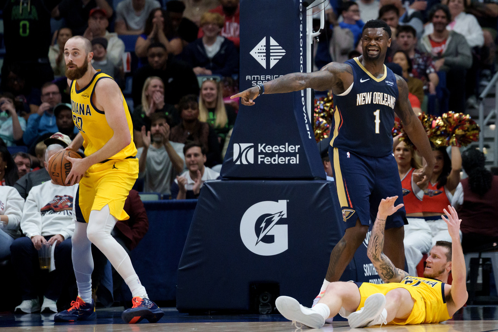 New Orleans Pelicans forward Zion Williamson (1) asks for a foul after dunking against Indiana Pacers center Jay Huff, left, and guard Taelon Peter, bottom right, during the first half of an NBA basketball game in New Orleans, Saturday, Dec. 20, 2025. (AP Photo/Matthew Hinton)