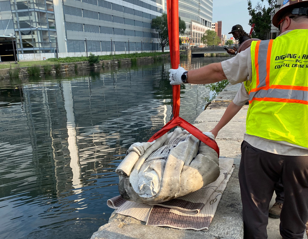 In this photo provided by Nino Mangione, a statue of Christopher Columbus is pulled out of the Inner Harbor in Baltimore, July 6, 2020, after protesters had thrown the statue into the harbor. (Nino Mangione via AP)