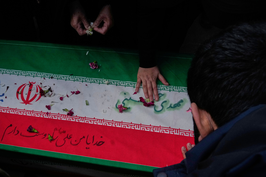 Relatives mourn over the flag draped coffin of Mehdi Hosseini who was killed in a U.S.-Israeli strike during his burial ceremony at Behesht-e Zahra cemetery in Tehran, Iran, Monday, March 9, 2026. (AP Photo/Vahid Salemi)