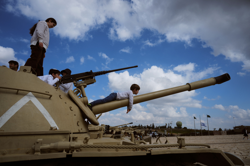 People climb on old tanks at the Armored Corps memorial site during a ceremony marking Israel's annual Memorial Day for the soldiers who died in the nation's conflicts and victims of nationalistic attacks, in Latrun, Israel, Tuesday, April 21, 2026. (AP Photo/Ariel Schalit)