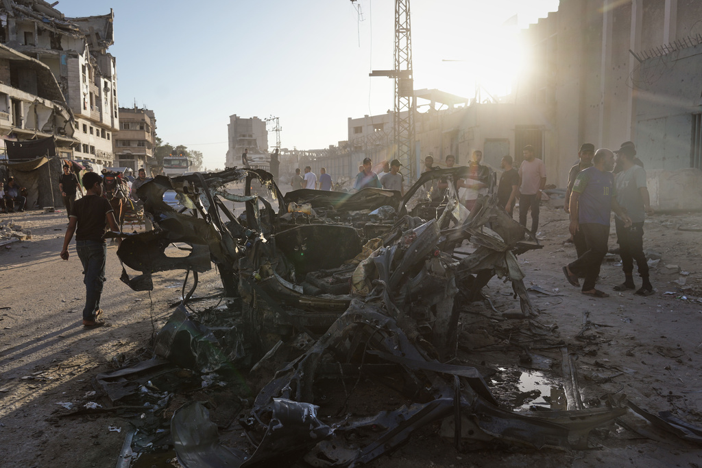 Palestinians inspect the wreckage of a car after it was hit by an Israeli strike in Gaza City, Sunday, Sept. 27, 2026. (AP Photo/Jehad Alshrafi)
