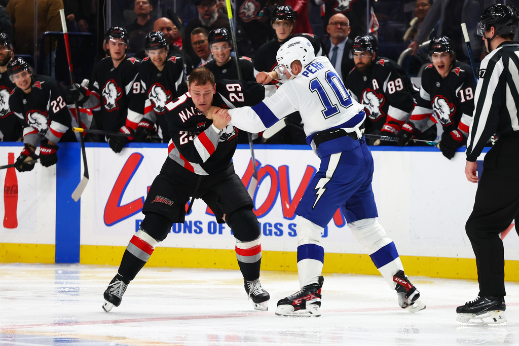 Buffalo Sabres left wing Beck Malenstyn (29) and Tampa Bay Lightning right wing Corey Perry (10) fight during the second period of an NHL hockey game, Sunday, March 8, 2026, in Buffalo, N.Y. (AP Photo/Jeffrey T. Barnes)