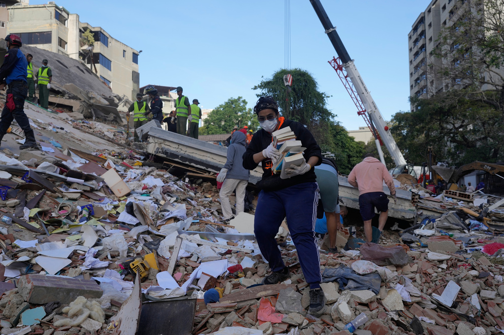 Residents search through the rubble of a building that collapsed in an earthquake in Caracas, Venezuela, Thursday, June 25, 2026. (AP Photo/Ariana Cubillos)