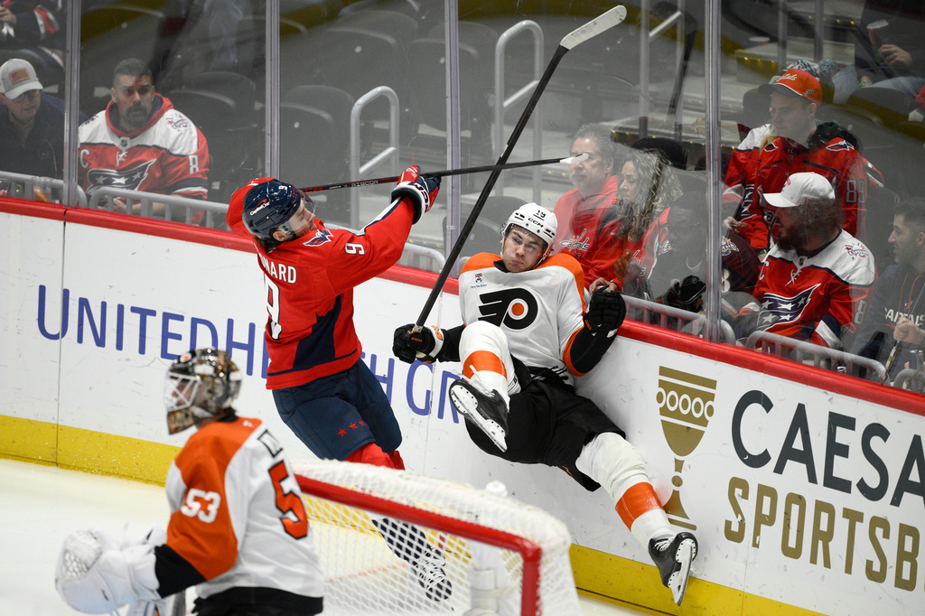 Washington Capitals right wing Ryan Leonard (9) hits Philadelphia Flyers defenseman Hunter McDonald (19) during the third period of an NHL hockey game, Wednesday, Oct. 28, 2026, in Washington. (AP Photo/Nick Wass)