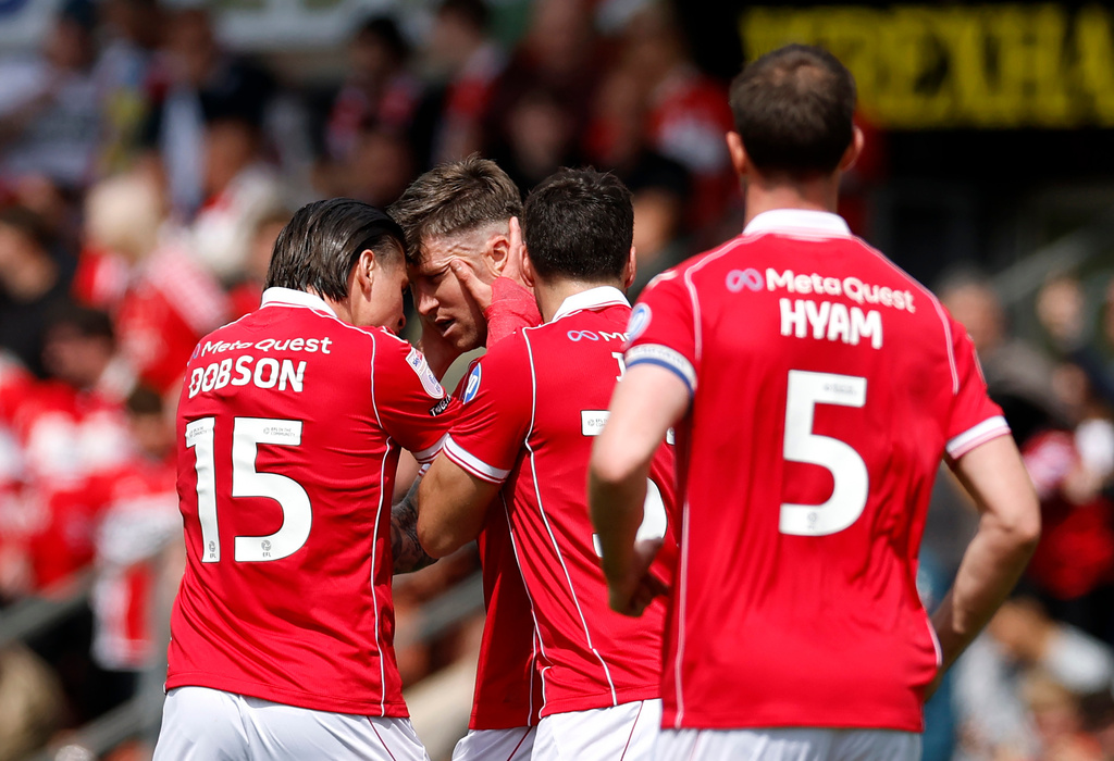 Wrexham's Josh Windass, second left, celebrates scoring his side's first goal of the game with teammates, during the EFL Championship soccer match between Wrexham and Middlesbrough, in Wrexham, Wales, Saturday May 2, 2026. (Cody Froggatt/PA via AP)