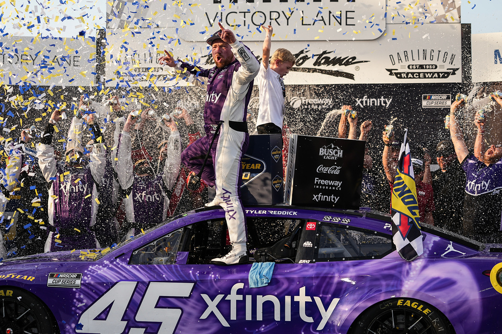 Tyler Reddick, center, celebrates in Victory Lane after winning a NASCAR Cup Series auto race, Sunday, March 22, 2026, in Darlington, S.C.(AP Photo/Matt Kelley)