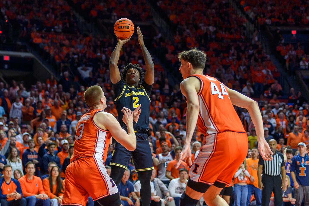 Michigan's L.J. Cason (2) looks to shoot between Illinois' Ben Humrichous, left, and Zvonimir Ivisic, right, during the second half of an NCAA college basketball game Friday, Feb. 27, 2026, in Champaign, Ill. (AP Photo/Craig Pessman)