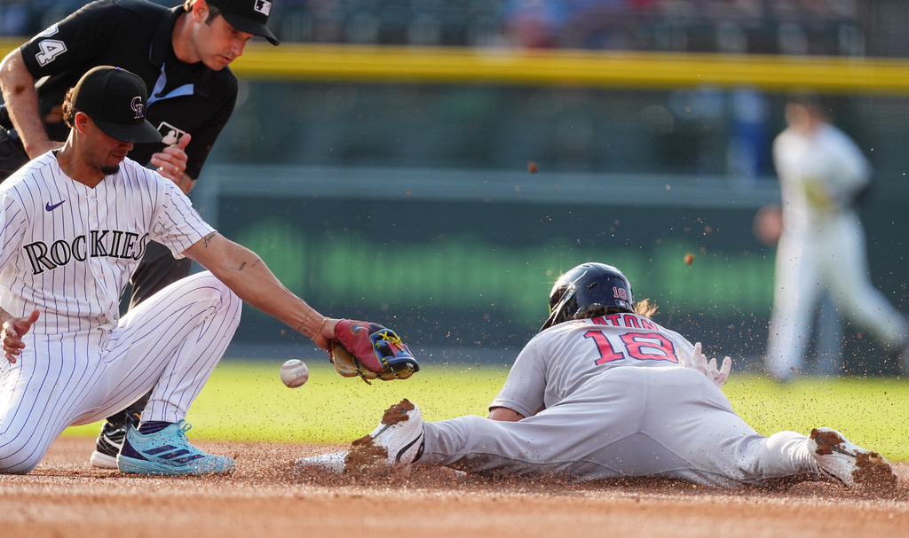 Boston Red Sox's Nate Eaton, right, steals second base as Colorado Rockies shortstop Ezequiel Tovar, front left, bobbles the throw while second base umpire John Tumpane looks on in the first inning of a baseball game Tuesday, June 23, 2026, in Denver. (AP Photo/David Zalubowski)