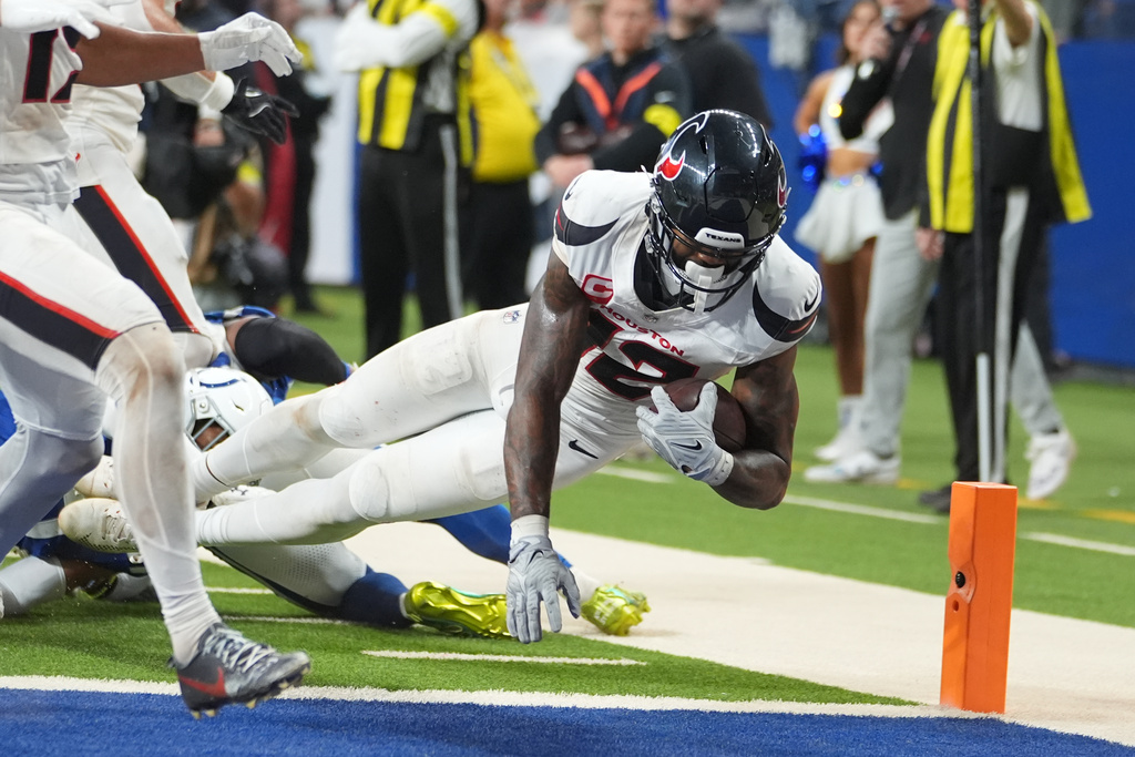 Houston Texans' Nico Collins (12) scores a touchdown against the Indianapolis Colts during the second half of an NFL football game Sunday, Nov. 30, 2025, in Indianapolis. (AP Photo/Michael Conroy)