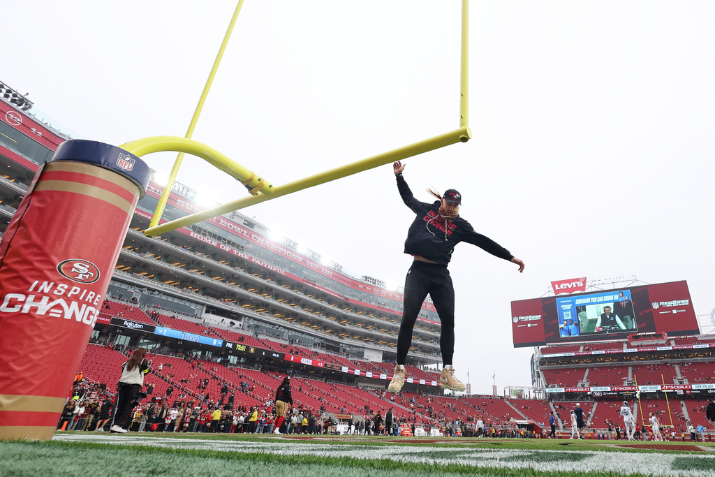 San Francisco 49ers tight end George Kittle jumps to touch the goalpost before an NFL football game against the Tennessee Titans, Sunday, Dec. 14, 2025, in Santa Clara, Calif. (AP Photo/Jed Jacobsohn)