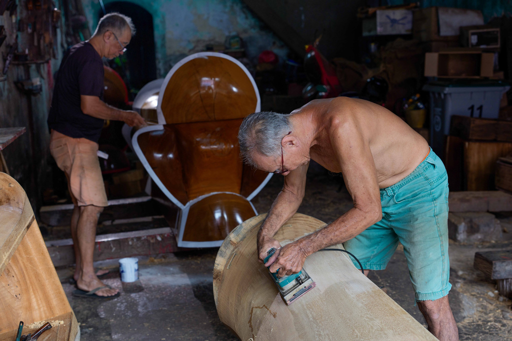 Traditional Chinese coffin maker Goh Khuay Par, right, carves a Mei Hua coffin as his brother Goh Khuay Hou paints another at their workshop in Muar, Johor state, Malaysia, Thursday, Sept. 3, 2026. (AP Photo/Vincent Thian)