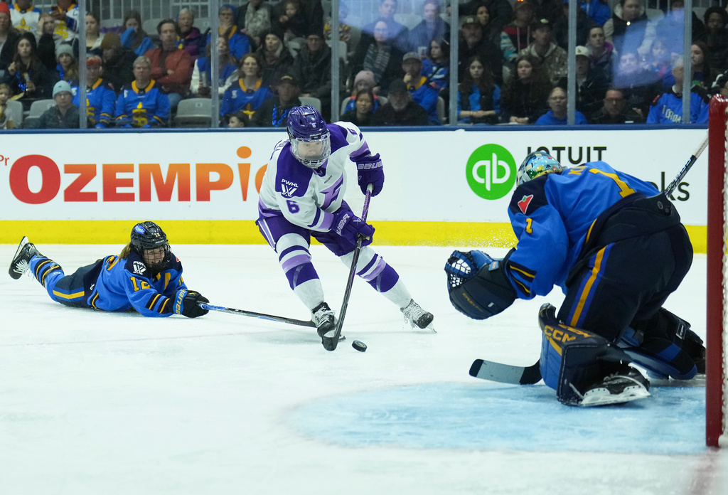 Toronto Sceptres goaltender Raygan Kirk (1) makes a save against Minnesota Frost forward Katy Knoll (6) as Toronto Sceptres defenseman Allie Munroe (12) battles for the puck during the third period of a PWHL hockey game, in Toronto, Sunday, March 8, 2026. (Nathan Denette/The Canadian Press via AP)