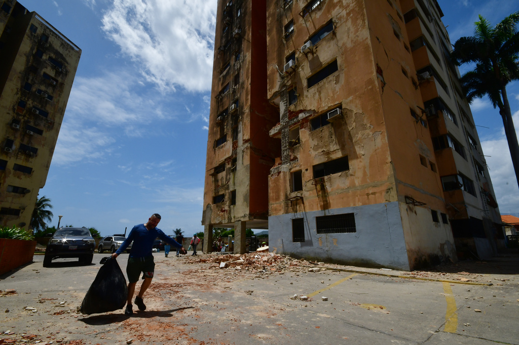 A man walks past a building damaged by earthquakes that struck Puerto Cabello, Venezuela, a day earlier, Thursday, June 25, 2026. (AP Photo/Jacinto Oliveros)