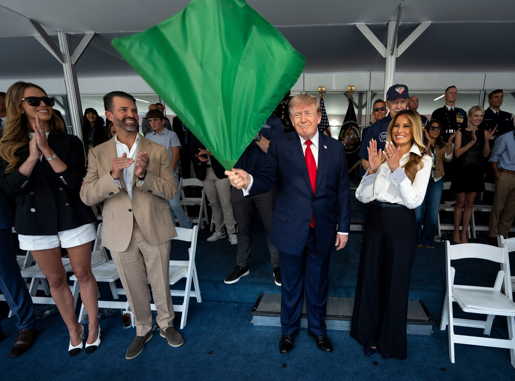 President Donald Trump waves the green flag to start the race alongside first lady Melania Trump, right, and from left, Bettina Trump and Donald Trump Jr. during the IndyCar Freedom 250 Grand Prix auto race, Sunday, Aug. 23, 2026, in Washington. (Doug Mills/The New York Times via AP, Pool)