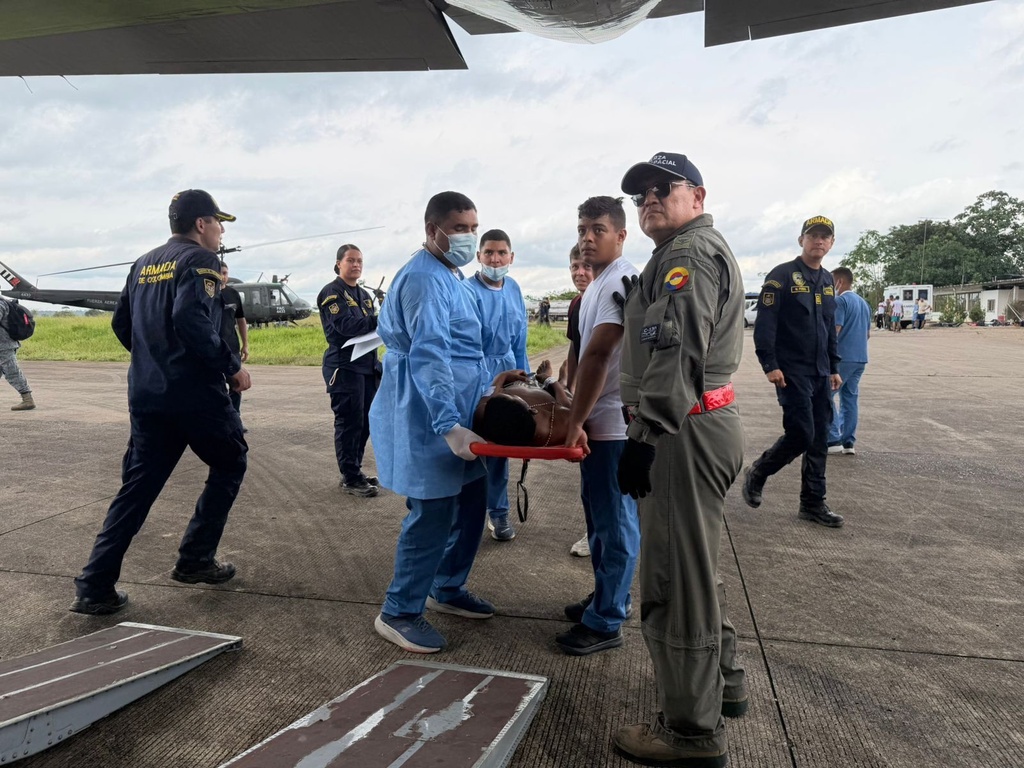 In this photo distributed by Colombia's Armed Forces press office, people who were injured on a military cargo plane that crashed shortly after take off are loaded on to another military plane to evacuate them for treatment, from Puerto Leguizamo, Colombia, Monday, March 23, 2026. (Colombia's Armed Forces press office via AP)