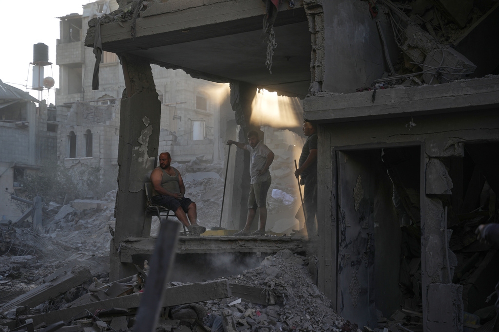 Palestinians clear the rubble of a building that was destroyed in an Israeli airstrike, at al-Maghazi refugee camp, central Gaza Strip, Friday, June 12, 2026. (AP Photo/Abdel Kareem Hana)