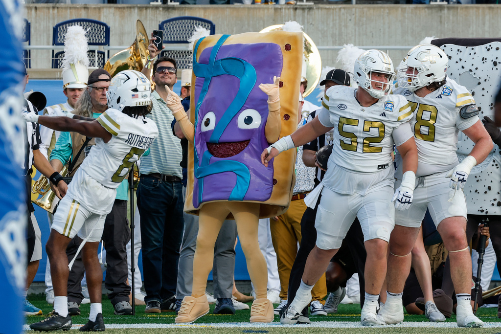 Georgia Tech celebrate a touch down with the pop-tart mascot against BYU during the first half of the Pop-Tarts Bowl NCAA college football game, Saturday, Dec. 27, 2025, in Orlando, Fla. (AP Photo/Kevin Kolczynski)