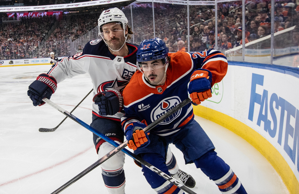 Columbus Blue Jackets' Boone Jenner and Edmonton Oilers' Matt Savoie battle on the corner during the first period of an NHL hockey game, in Edmonton, Alberta, Monday, Nov. 10, 2025. (Jason Franson/The Canadian Press via AP)