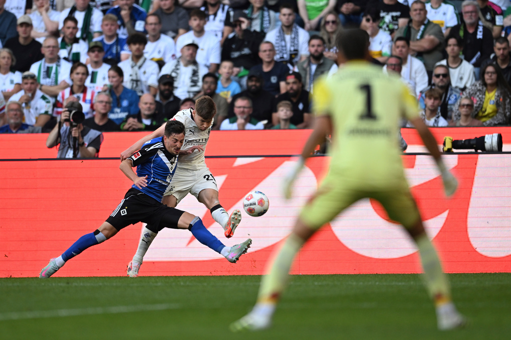 Hamburg's Giorgi Gocholeishvili, left, in a duel with Borussia's Lukas Ullrich during the German Bundesliga soccer match between Borussia Mönchengladbach and Hamburger SV at Borussia-Park in Mönchengladbach, Germany, Sunday Aug. 24, 2025. (Fabian Strauch/dpa via AP)