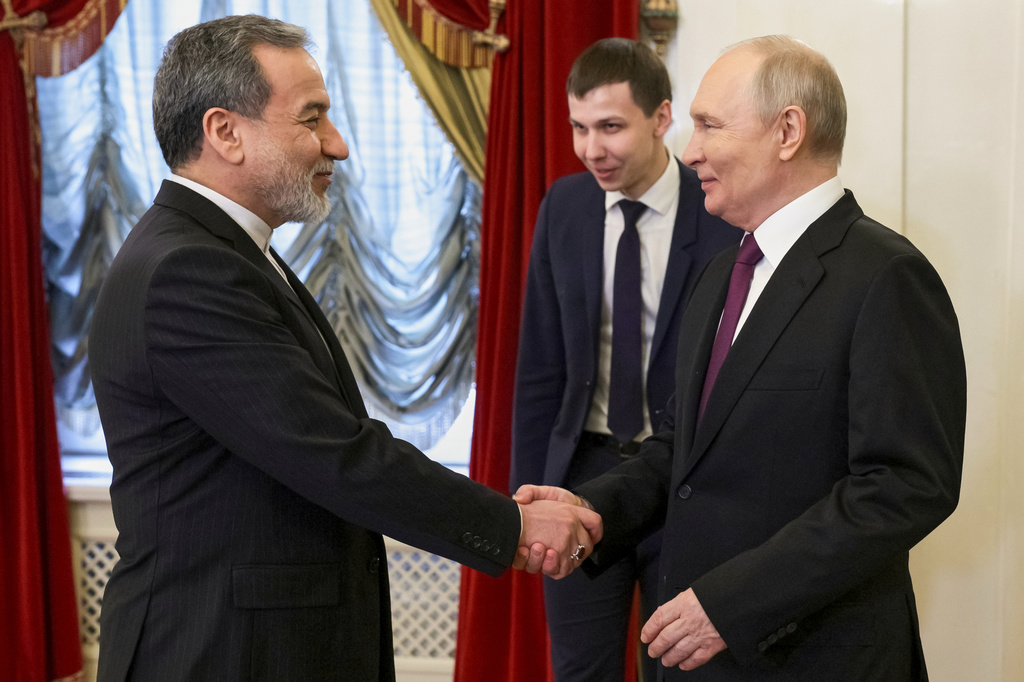 Russian President Vladimir Putin, right, shakes hands with Iranian Foreign Minister Abbas Araghchi during their meeting at the Boris Yeltsin Presidential Library, in St. Petersburg, Russia, Monday, April 27, 2026. (Gavriil Grigorov, Sputnik, Kremlin Pool Photo via AP)