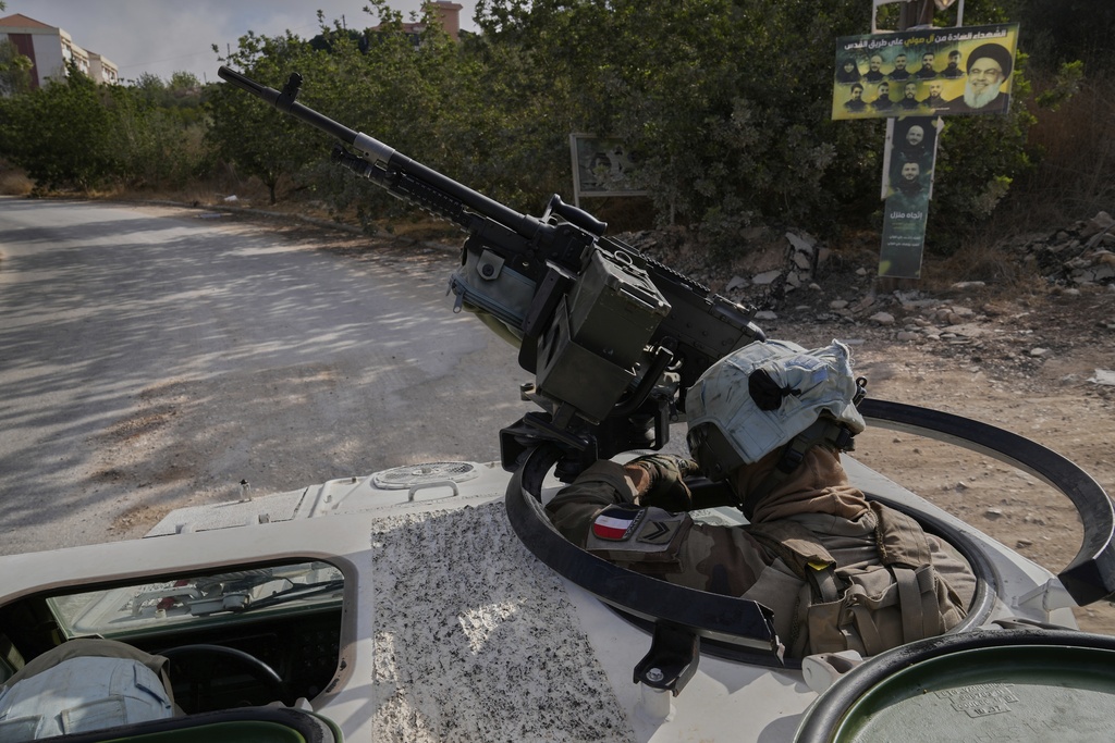 A French U.N. peacekeeper rides on an armored vehicle during a patrol along the Lebanese-Israeli border in the village of Kfra Kila, southern Lebanon, Wednesday, Aug. 20, 2025. (AP Photo/Hussein Malla)