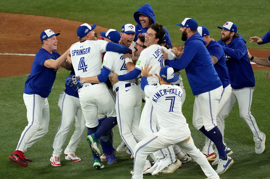 Toronto Blue Jays players celebrate after their Game 7 win over the Seattle Mariners to take baseball's American League Championship Series in Toronto, Monday, Oct. 20, 2025. (Chris Young/The Canadian Press via AP)