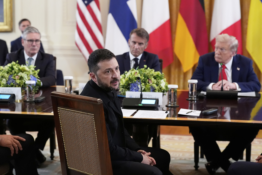 Ukraine's President Volodymyr Zelenskyy speaks as British Prime Minister Keir Starmer, seated from background left, France's President Emmanuel Macron and President Donald Trump listen during a meeting in the East Room of the White House, Monday, Aug. 18, 2025, in Washington. (AP Photo/Alex Brandon)