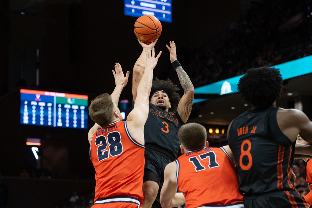 Miami guard Tre Donaldson (3) scores over /v28 and Virginia Thijs de Ridder (28) and Johann Grünloh (17) during the first half of an NCAA college basketball game, Saturday, Feb. 21, 2026, in Charlottesville, Va. (AP Photo/Robert Simmons)