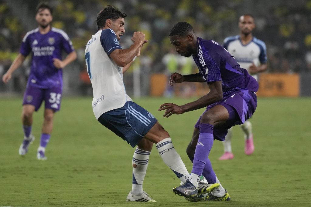 Nashville SC midfielder Gastón Brugman, left, and Orlando City forward Tyrese Spicer, right, vie for the ball during the first half of an MLS soccer match Saturday, Aug. 23, 2025, in Nashville, Tenn. (AP Photo/George Walker IV)