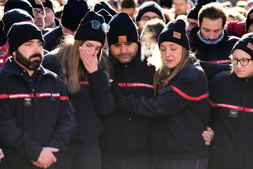 Firefighters cry as they attend a memorial march in Crans-Montana, Swiss Alps, Switzerland, Sunday, Jan. 4, 2026, after a devastating fire in Le Constellation bar left dead and injured during the New Year's celebrations. (AP Photo/Baz Ratner)