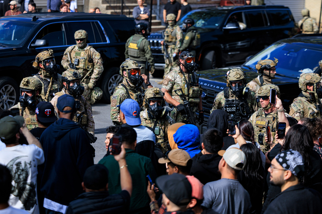 Government officials watch protesters gathering in Chicago, Tuesday, Oct. 14, 2025. (Anthony Vazquez/Chicago Sun-Times via AP)