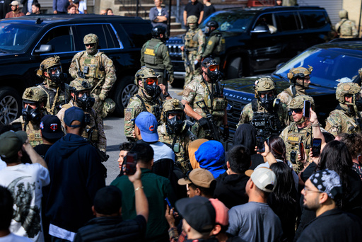 Government officials watch protesters gathering in Chicago, Tuesday, Oct. 14, 2025. (Anthony Vazquez/Chicago Sun-Times via AP) Government officials watch protesters gathering in Chicago, Tuesday, Oct. 14, 2025. (Anthony Vazquez/Chicago Sun-Times via AP)