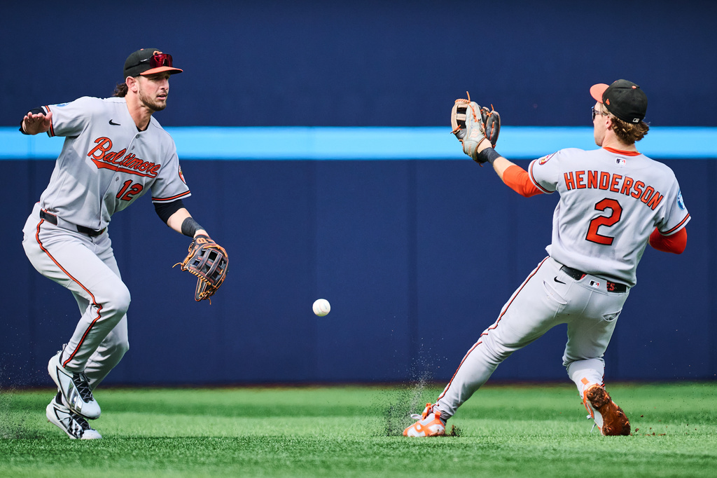 Baltimore Orioles' Dylan Beavers (12), left, and Gunnar Henderson (2) can't make the catch during second inning of a baseball game against the Toronto Blue Jays in Toronto, on Saturday, Sept. 12, 2026. (Sammy Kogan/The Canadian Press via AP)