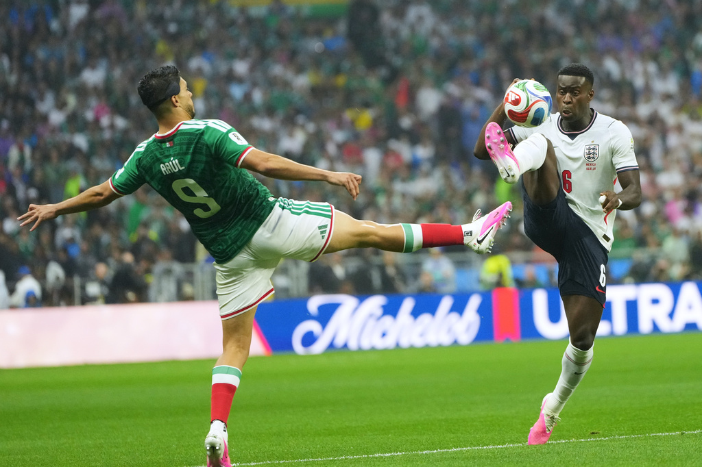 Mexico's Raul Jimenez, left, and England's Marc Guehi challenge for the ball during the World Cup round of 16 soccer match between Mexico and England in Mexico City, Sunday, July 5, 2026. (AP Photo/Moises Castillo)