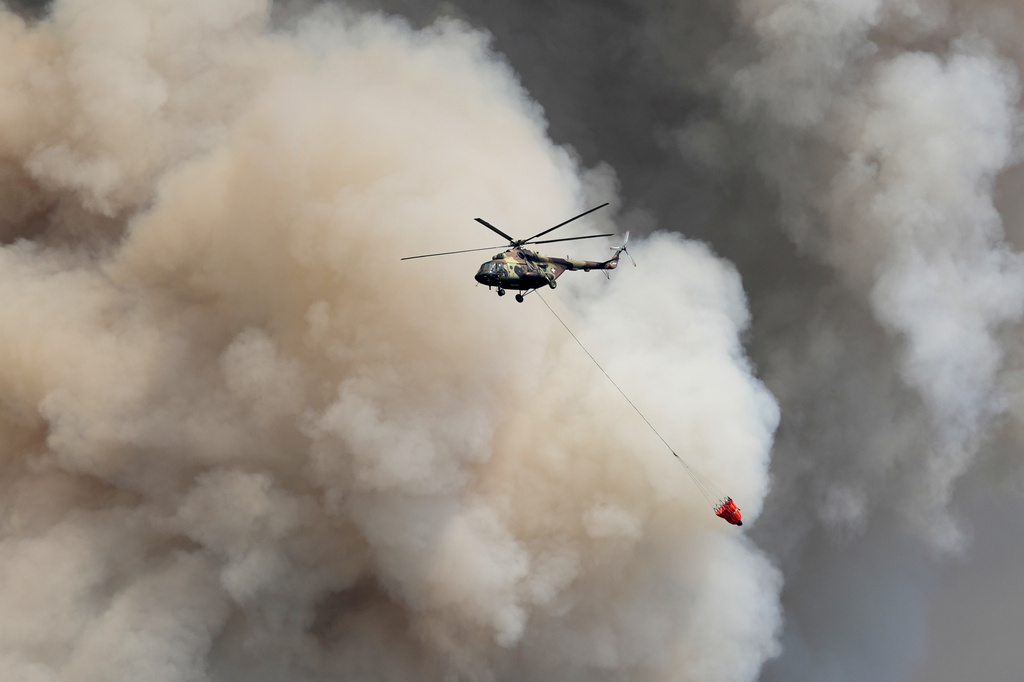 A Serbian Army helicopter battles a fire in Deliblatska Pescara (Deliblato Sands), near the village of Sumarak, 70 kilometers north-west of Belgrade, Serbia, Friday, Aug. 7, 2026. (AP Photo/Darko Vojinovic)