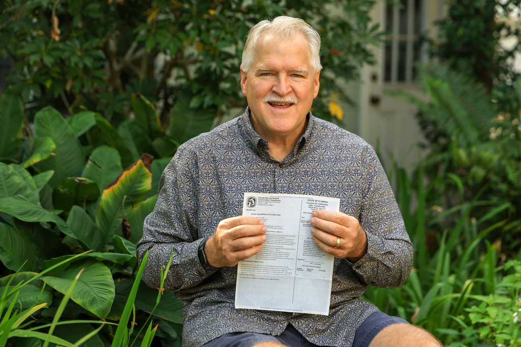 Joel Cleveland poses with his Florida bear hunting permit Friday, Dec. 5, 2025, in Tampa, Fla. Cleveland applied for the hunt permit lottery with the intention of not using it in an attempt to save a bear from the hunt. (AP Photo/Mike Carlson)