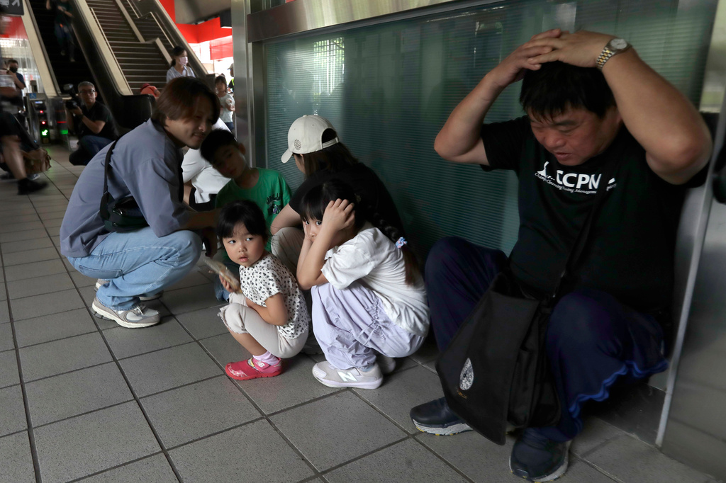 People take cover inside at a MRT station during the Urban Resilience (Air-Defense) Exercise, part of the annual Han Kuang military exercises in Taipei, Taiwan, Thursday, Aug. 13, 2026. (AP Photo/Chiang Ying-ying)
