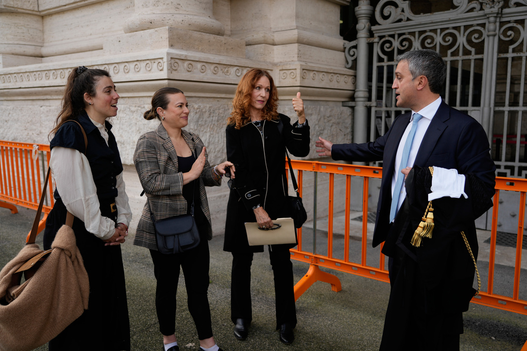 Italian Lawyer Marco Mellone, right, greets Alexis Traino, left, Jacqueline Romano and Karen Bonadio from United States, outside Italy's highest Court of Cassation, in Rome, Tuesday, April 14, 2026, prior to the start of a hearing to argue against the new citizenship law that restricts citizenship by descent. (AP Photo/Gregorio Borgia)