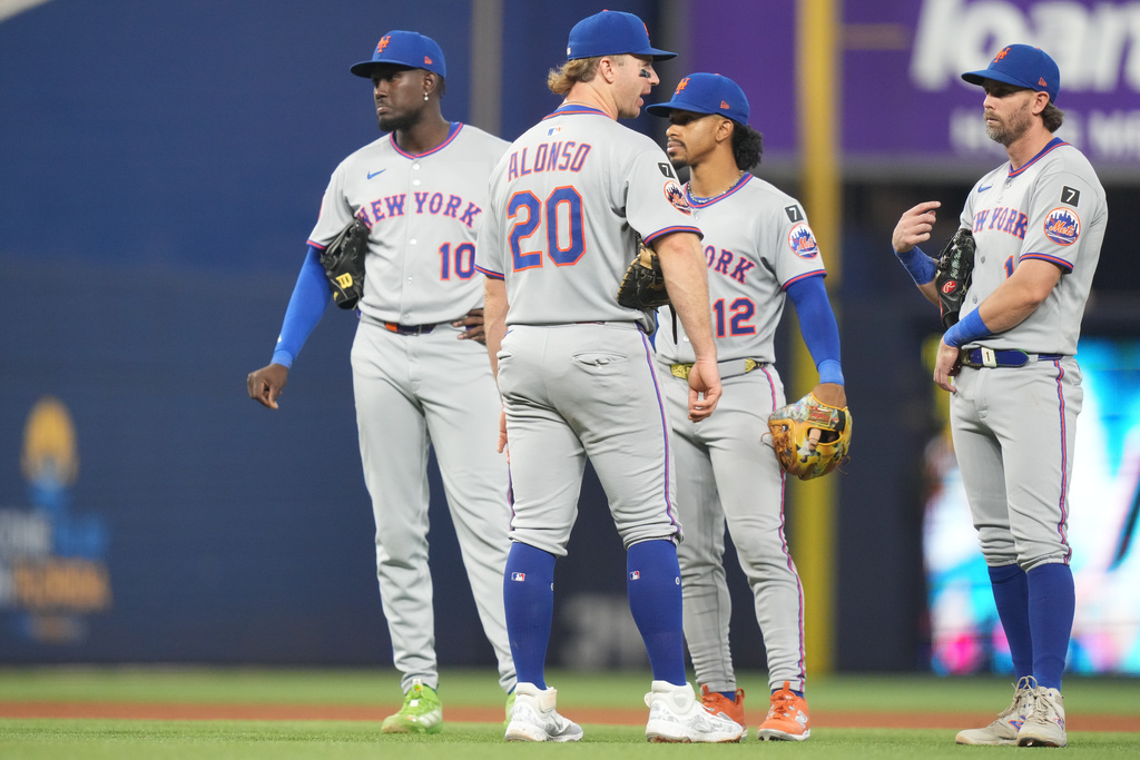 New York Mets third baseman Ronny Mauricio (10), first baseman Pete Alonso (20), shortstop Francisco Lindor (12) and second baseman Jeff McNeil, right, stand Lon the field during a pitching change in the fourth inning of a baseball game, Sunday, Sept. 28, 2025, in Miami. (AP Photo/Lynne Sladky)