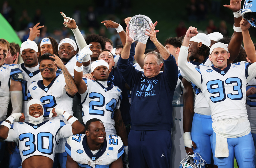 North Carolina head coach Bill Belichick, center right, and his team celebrate after defeating TCU in an NCAA college football game in Dublin, Ireland, Saturday, Aug. 29, 2026. (AP Photo/Peter Morrison)