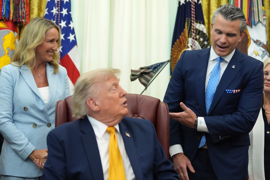 Defense Secretary Pete Hegseth, from right, speaks as President Donald Trump and Jennifer Hegseth listen during a meeting about military families, in the Oval Office of the White House, Monday, Aug. 3, 2026, in Washington. (AP Photo/Alex Brandon)