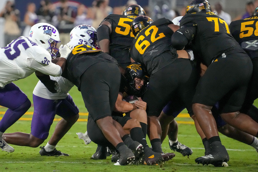 Arizona State Sun Devils quarterback Sam Leavitt (10) goes low against TCU Horned Frogs defense and gets a first down during the first half of an NCAA college football game Friday, Sept. 26, 2025, in Tempe, Ariz. (AP Photo/Darryl Webb)