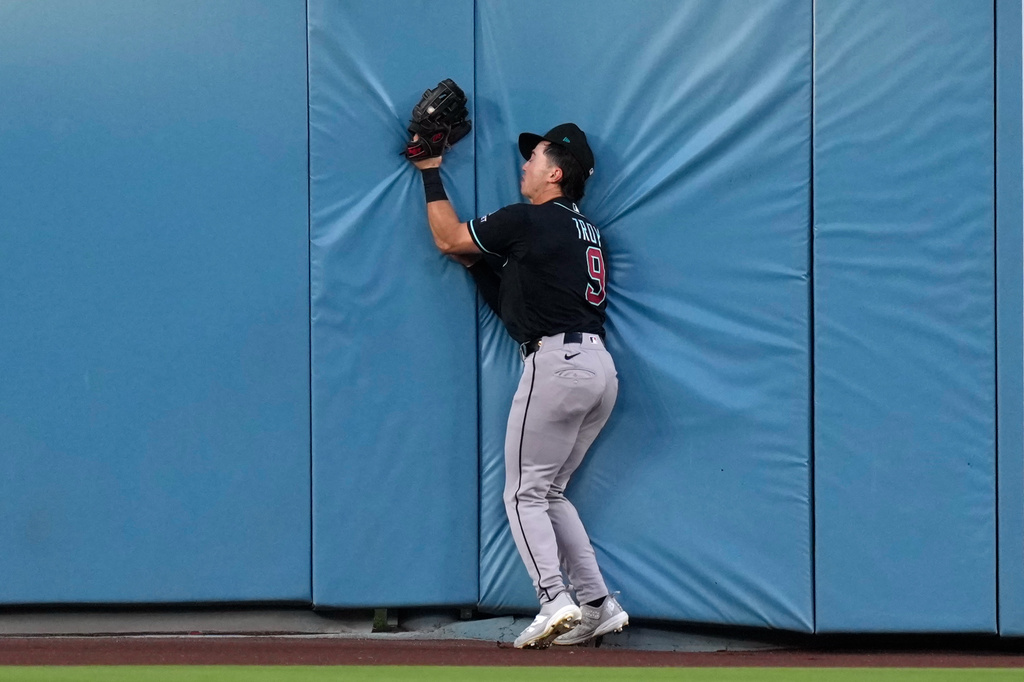 Arizona Diamondbacks center fielder Tommy Troy collides with the wall after making a catch on a ball hit by Los Angeles Dodgers' Teoscar Hernández during the fifth inning of a baseball game Saturday, July 11, 2026, in Los Angeles. (AP Photo/Mark J. Terrill)