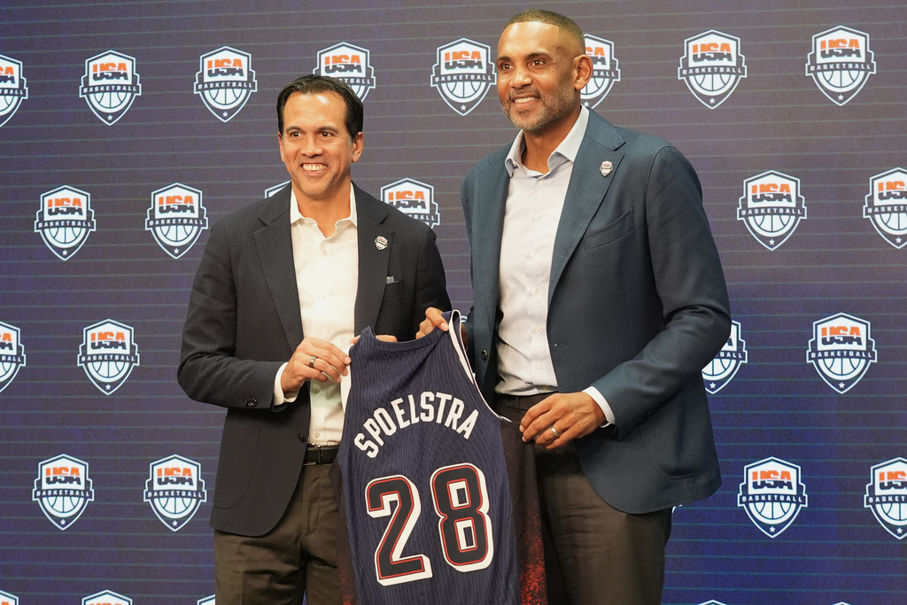 Erik Spoelstra, USA Basketball men's national team head coach, left, and Grant Hill, USA Basketball men's national team managing director, hold up a jersey during a news conference Thursday, Oct. 16, 2025, in Miami. (AP Photo/Marta Lavandier)