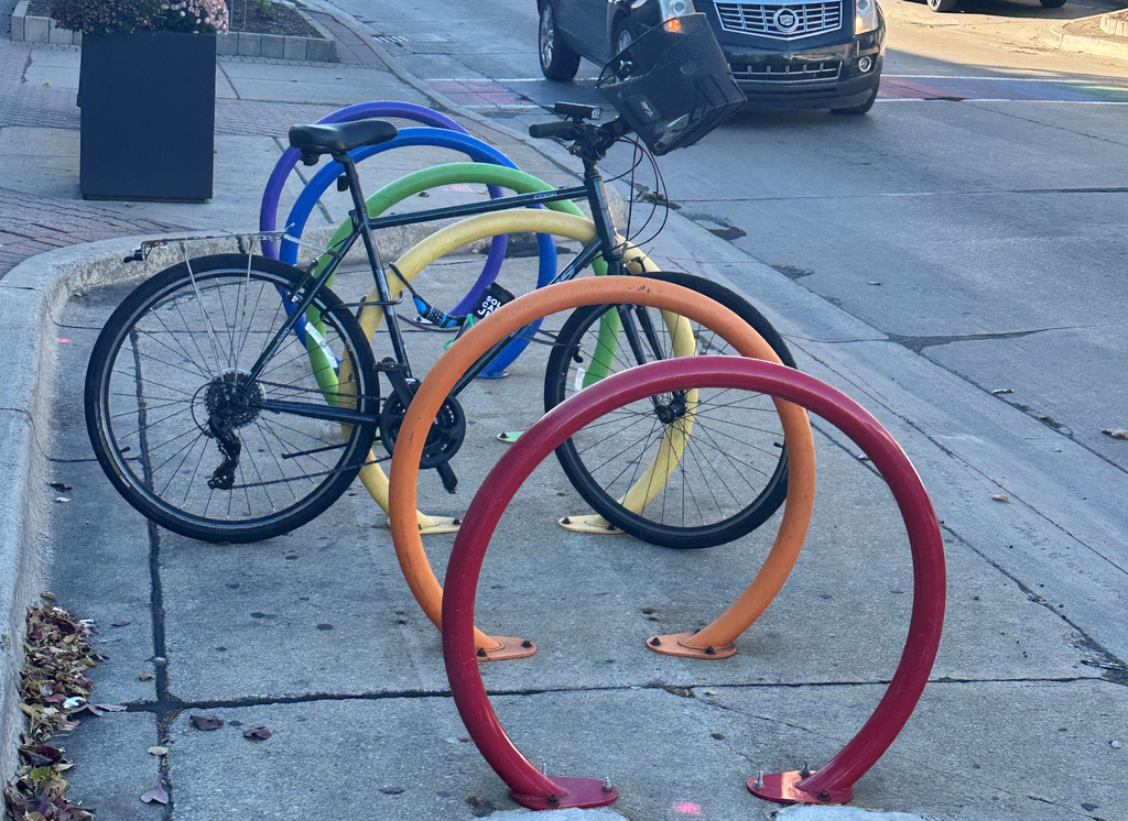 A bicycle is parked at a rainbow-themed bike rack along Nine Mile Road in Ferndale, Mich., Monday, Nov. 3, 2025. (AP Photo/Corey Williams)