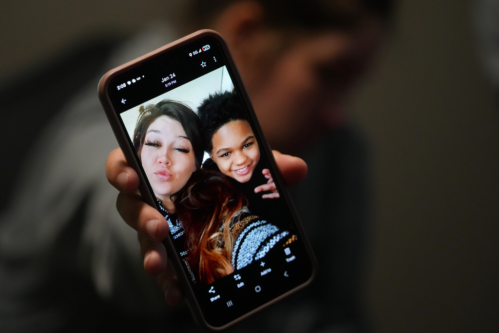 Cheyenne Hangaman shows a photograph of her and her son, EJ, 9, who along with his two brothers Kaleb, 8, and Howard, 6, drowned in a frozen pond Tuesday, Jan. 27, 2026, in Bonham, Texas. (AP Photo/Julio Cortez)